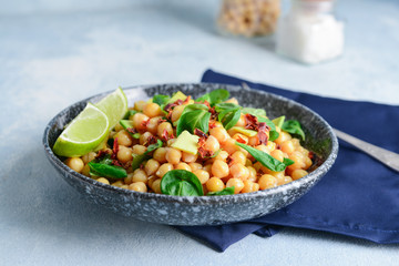 Plate with tasty chickpea salad on table