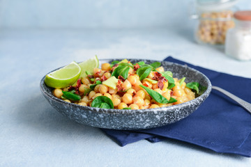 Plate with tasty chickpea salad on table