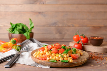 Plate with tasty chickpea salad on table
