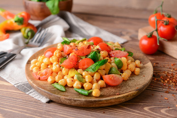Plate with tasty chickpea salad on table