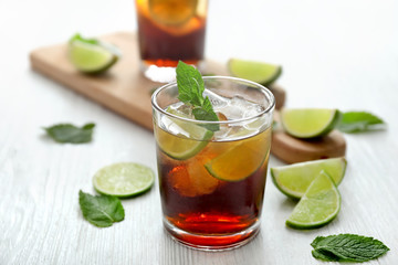 Glass of cold cola, lime and mint on table