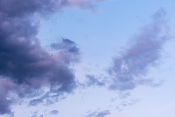 Fototapeta na wymiar Blue hour sky clouds background. Beautiful landscape with stormy clouds and purple sun on sky