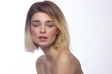 Close-up beautiful young woman face with clean perfect skin and hair. Portrait of beauty model with natural nude make up and hand near lips. Spa, skincare and wellness. Isolated on white background