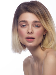 Fototapeta premium Close-up beautiful young woman face with clean perfect skin and hair. Portrait of beauty model with natural nude make up and hand near lips. Spa, skincare and wellness. Isolated on white background