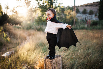Kid smiling costumed of dracula to halloween on the forest