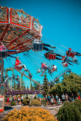 Obraz premium Colorful carrousel with kids on there. Chain swing carrousel in amusement park.