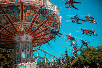 Colorful carrousel with kids on there. Chain swing carrousel in amusement park. © Маргарита Щипкова