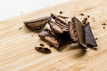 Ganache Filled Chocolate Bar Pieces on Wooden Board Ready to Eat.