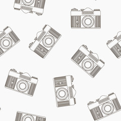 Decorative print with camera on white backdrop. Seamless pattern with randomly arranged line-drawn cameras.