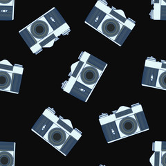Decorative print with camera on black backdrop. Seamless pattern with randomly arranged cameras.