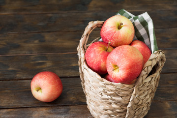 Apples in a basket on a wooden background. Autumn harvest