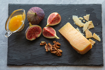 Fototapeta na wymiar Ripe hard cheese with honey and figs.Ripe Cheddar with Red Wine
