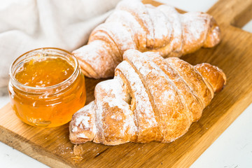 Croissant with jam on white.