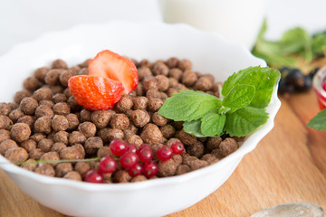 breakfast Healthy tasty breakfast chocolate balls with strawberries, raspberries, black currants and red currants.