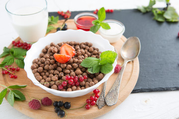 Healthy breakfast ingredients. Healthy tasty breakfast chocolate balls with strawberries, raspberries, black currants and red currants.