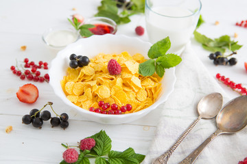 Muesli with berries and milk Healthy tasty breakfast cornflakes with strawberries, raspberries, black currants and red currants.
