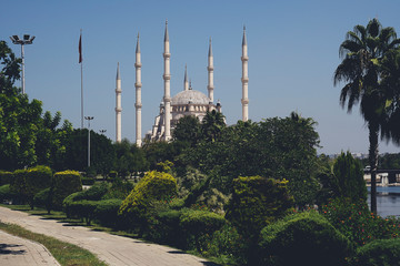 Fototapeta na wymiar Sabanci Central Mosque in Adana city of Turkey with Seyhan River and Trees. Mosque, Seyhan river and trees at Adana town in sunny day with blue clean sky.