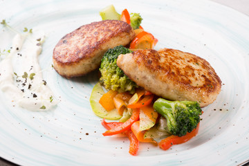 Meat cutlets served with steamed vegetables