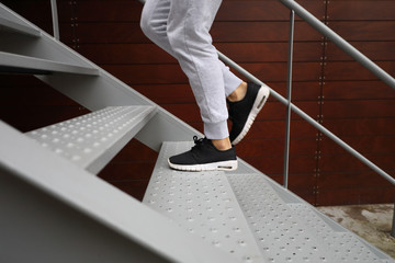 Detail of sporty woman running shoes while she is training climbing stairs. Urban fitness outdoor workout.