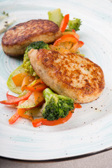 Meat cutlets served with steamed vegetables