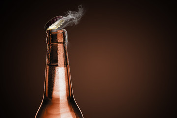 Cold wet bottle of chilled drink with drops. Opening of beer cap with the gas output.
