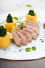 Smoked and sliced duck meat served with polenta