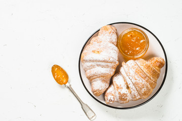 Croissant with jam on white.