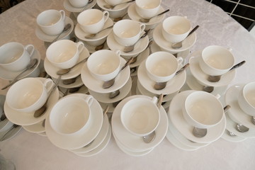 Stacked empty teacups with teaspoons and plates