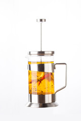 fresh hot winter lemon tea with chilli pepper in french press isolated on white background