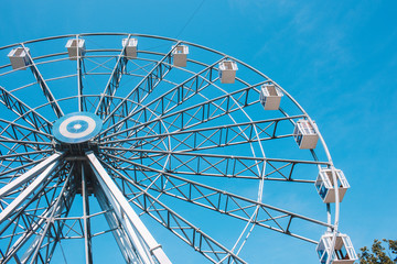 Ferris wheel in a park on a clear blue background.