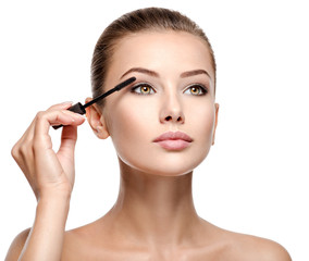 woman applying cosmetic mascara on eyelashes using curling brush