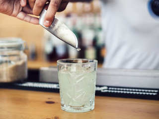 Male bartender adding ice with scoop
