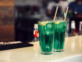 Decorated glasses of colourful green beverage