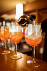 female bartender preparing aperol cocktail in a cocktail bar