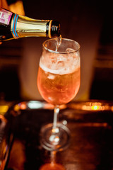 female bartender preparing aperol cocktail in a cocktail bar