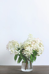 bouquet of white flower hydrangeas on a wooden background. vertical frame