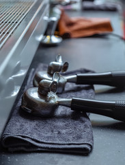 Marble Desktop. Blue cleaning cloth. Pair of coffee machine handles. Comparison of cold and warm colors. Warm light. Close-up lens