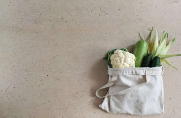 Zero waste food and plastic free shopping concept. Vegetables - zucchini, cucumbers, cauliflower, corn- in cotton bag. Green diet