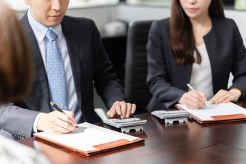 税の相談を受け、計算をする税理士（真顔）
