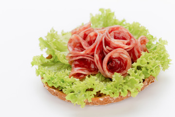 Sandwich with salami sausage on white background.