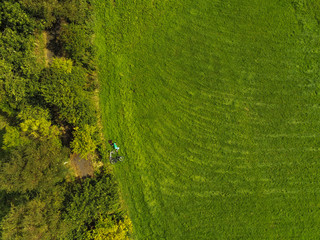 Aerial top view, Green field in a park, Teenager laying on a grass by bicycle. Concept outdoors activity, tourism.