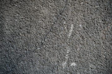 Texture of an old cracked concrete wall. Background image of a worn gray concrete surface