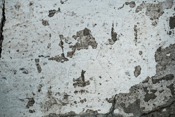 Texture of an old cracked concrete wall. Background image of a worn gray concrete surface