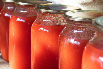 Glass jars with tomato juice.