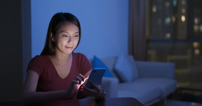 Woman use of smart phone online at home in the evening