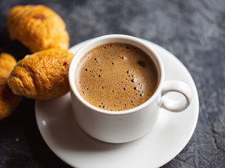 Cup of espresso and a small Breakfast croissants