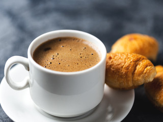 Cup of espresso and a small Breakfast croissants