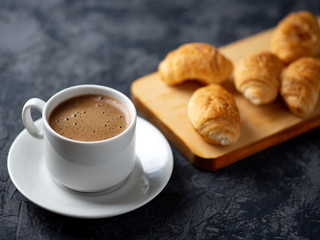 Cup of espresso and a small Breakfast croissants
