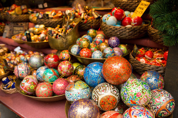 Fototapeta na wymiar Christmas souvenirs on the counter in Europe, Painted glass Christmas balls with fairy tales.