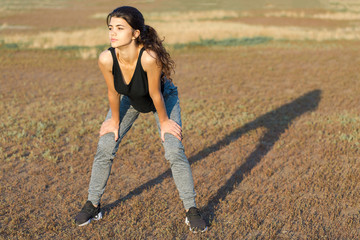 A young slim athletic girl in sportswear with snakeskin prints performs a set of exercises. Fitness...